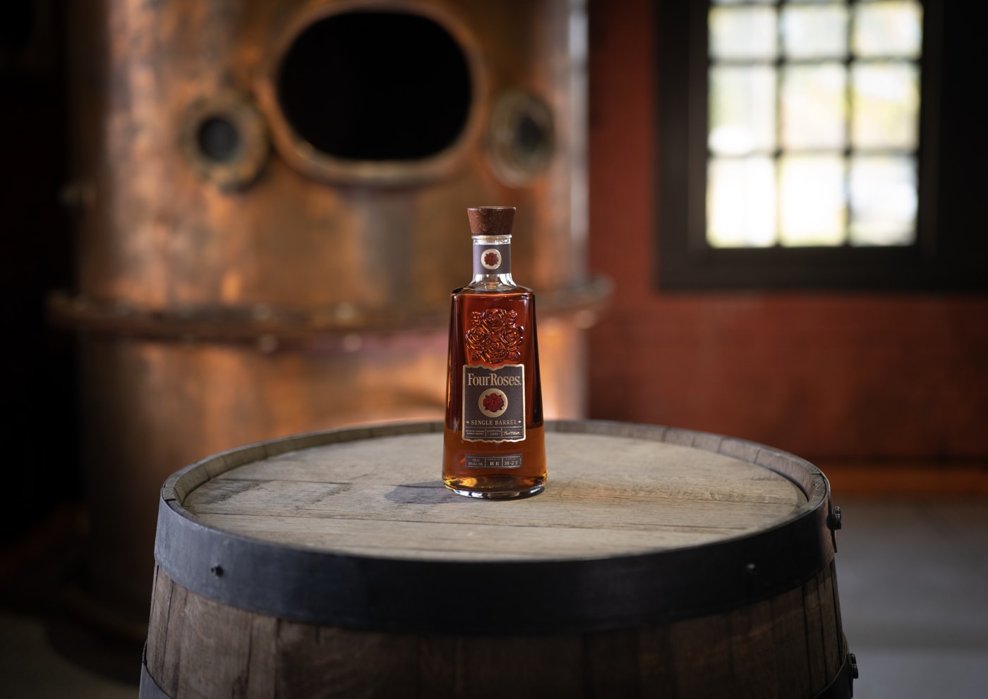 Four Roses Single Barrel bottle on a barrel in the distillery